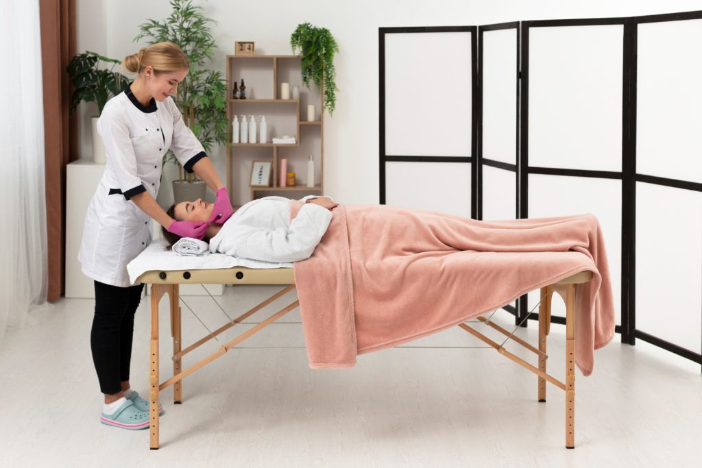 Spa Professional Treating Client on Massage Table with Clean Towels and Robe