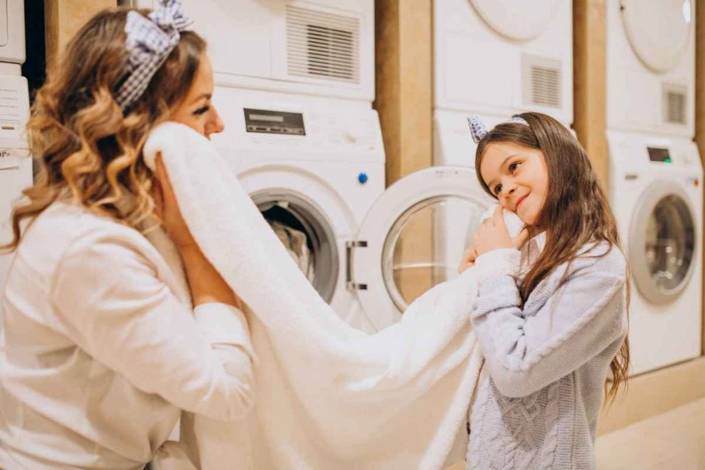 mother-with-daughter-doing-laundry-self-serviece-laundrette-min-1