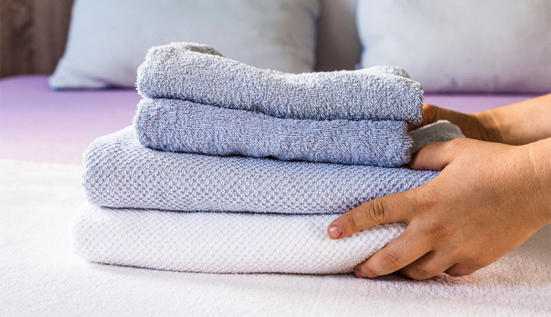 Washing complete A person stacks freshly laundered towels